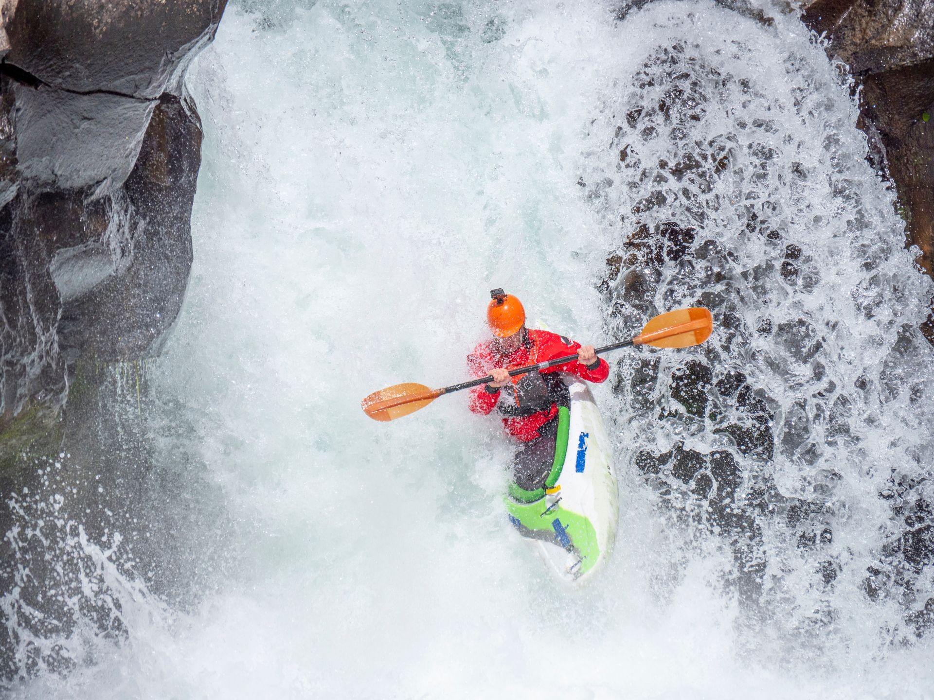 Extreme athlete whitewater kayaking over a waterfall on the McCloud River in northern California